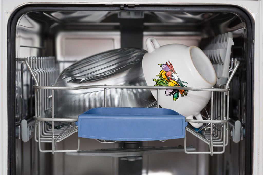 A blue baking dish and a lidded pot standing in the lower rack of an open dishwasher