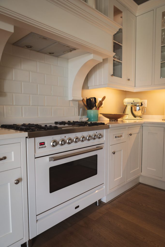 A cream professional-style range standing in a tiled alcove, a stand mixer on the counter beside it