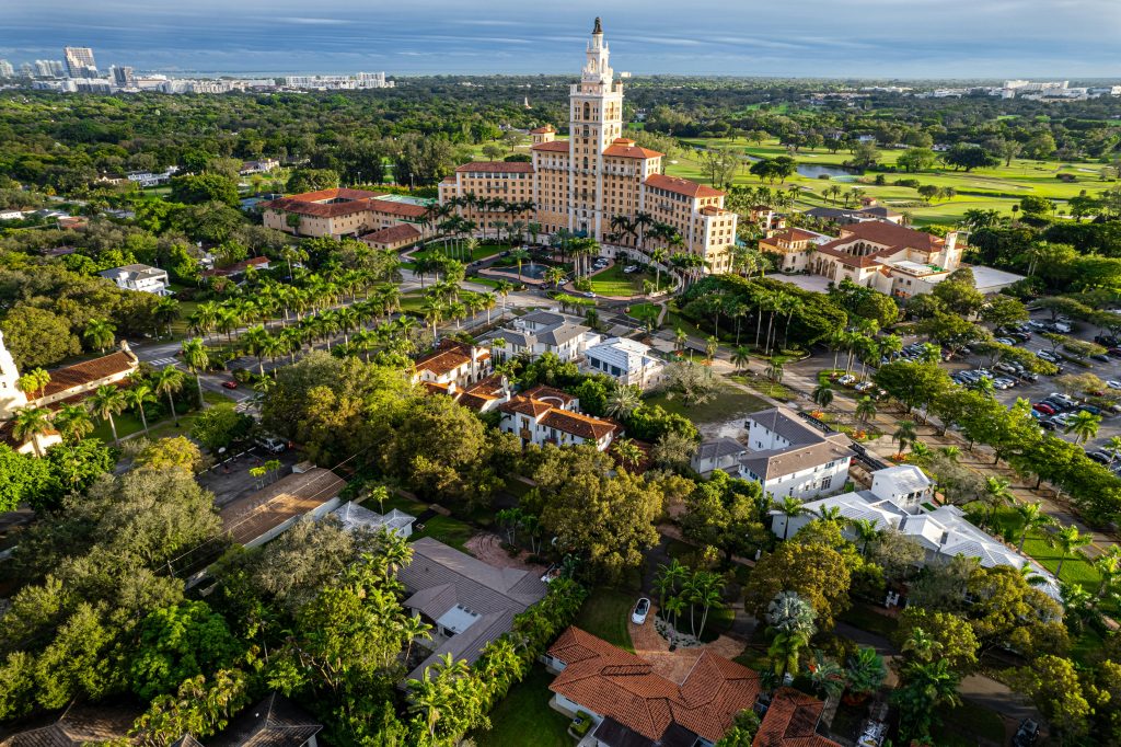 An aerial view of Coral Gables, its tower rising out of the tree canopy