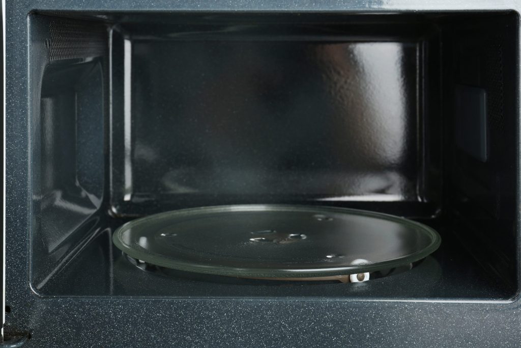 The empty cavity and turntable of a microwave with the door open